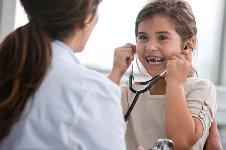 Doctor letting a girl patient use her stethoscope